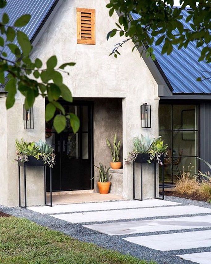 Entrada de casa con plantas en macetas y lámparas