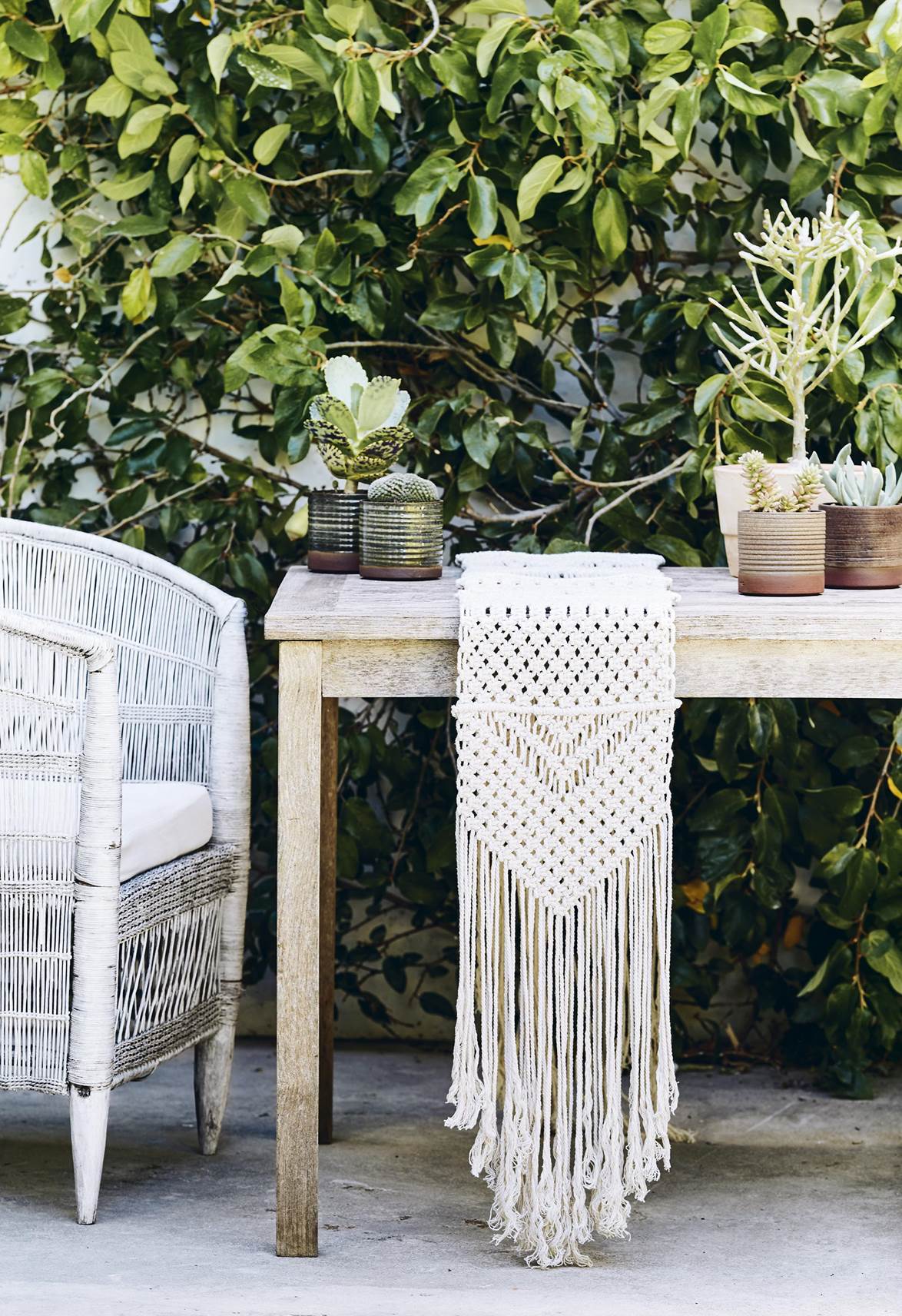 Mesa y silla en exterior con camino de macramé
