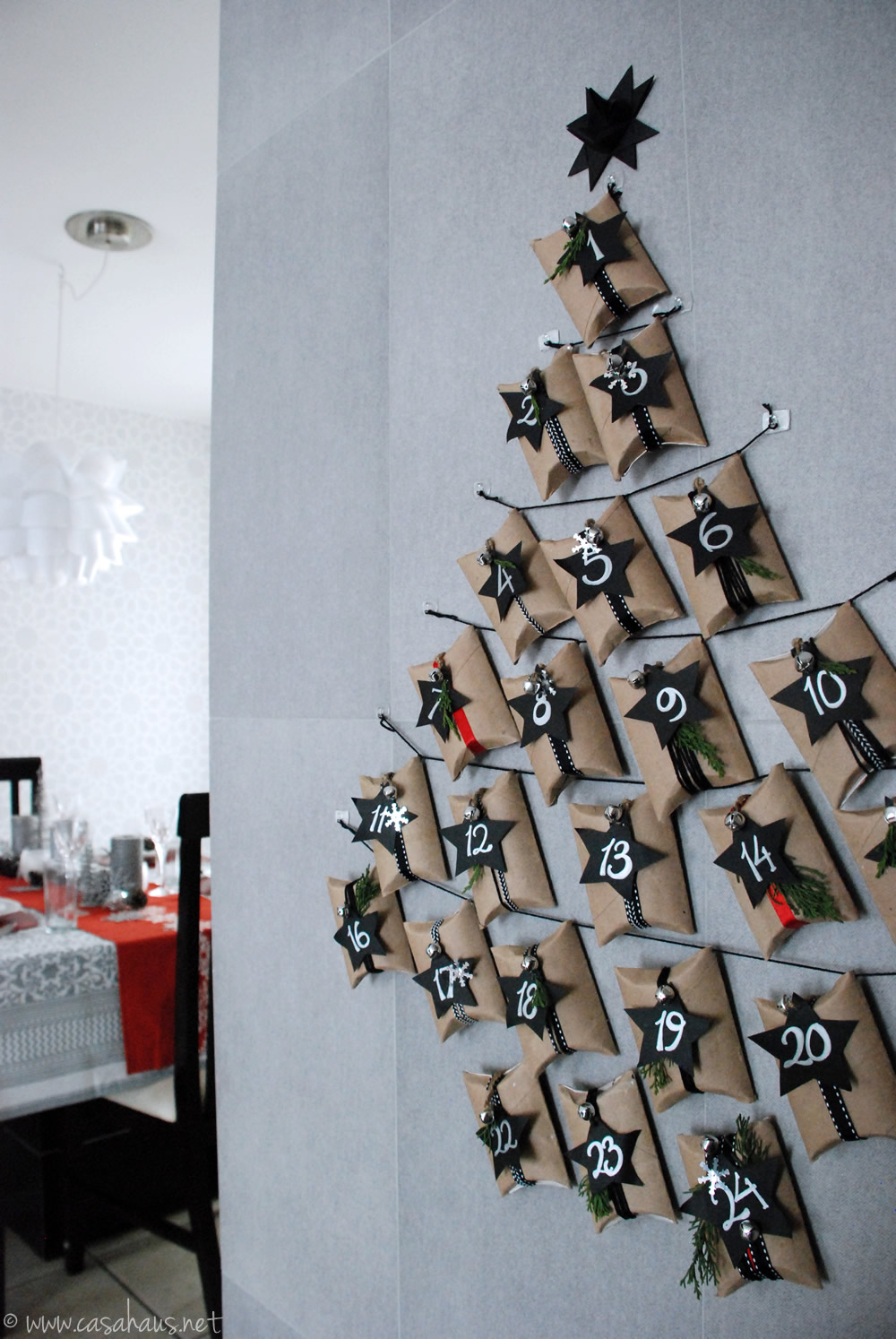 Calendario de adviento hecho con rollos de papel sanitario, sobre la pared