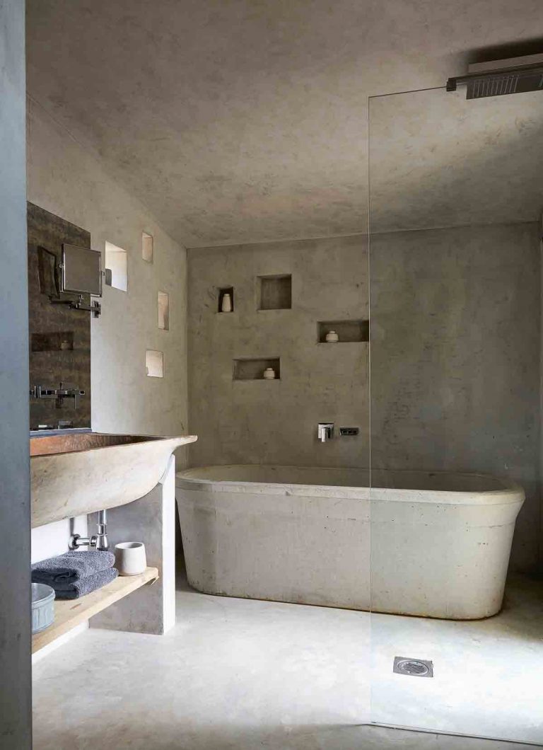 Baño moderno con muros y tina de concreto