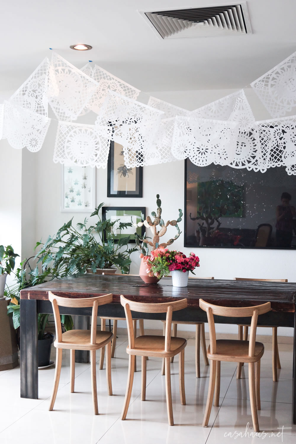 Mesa rústica con papel picado colgado del techo