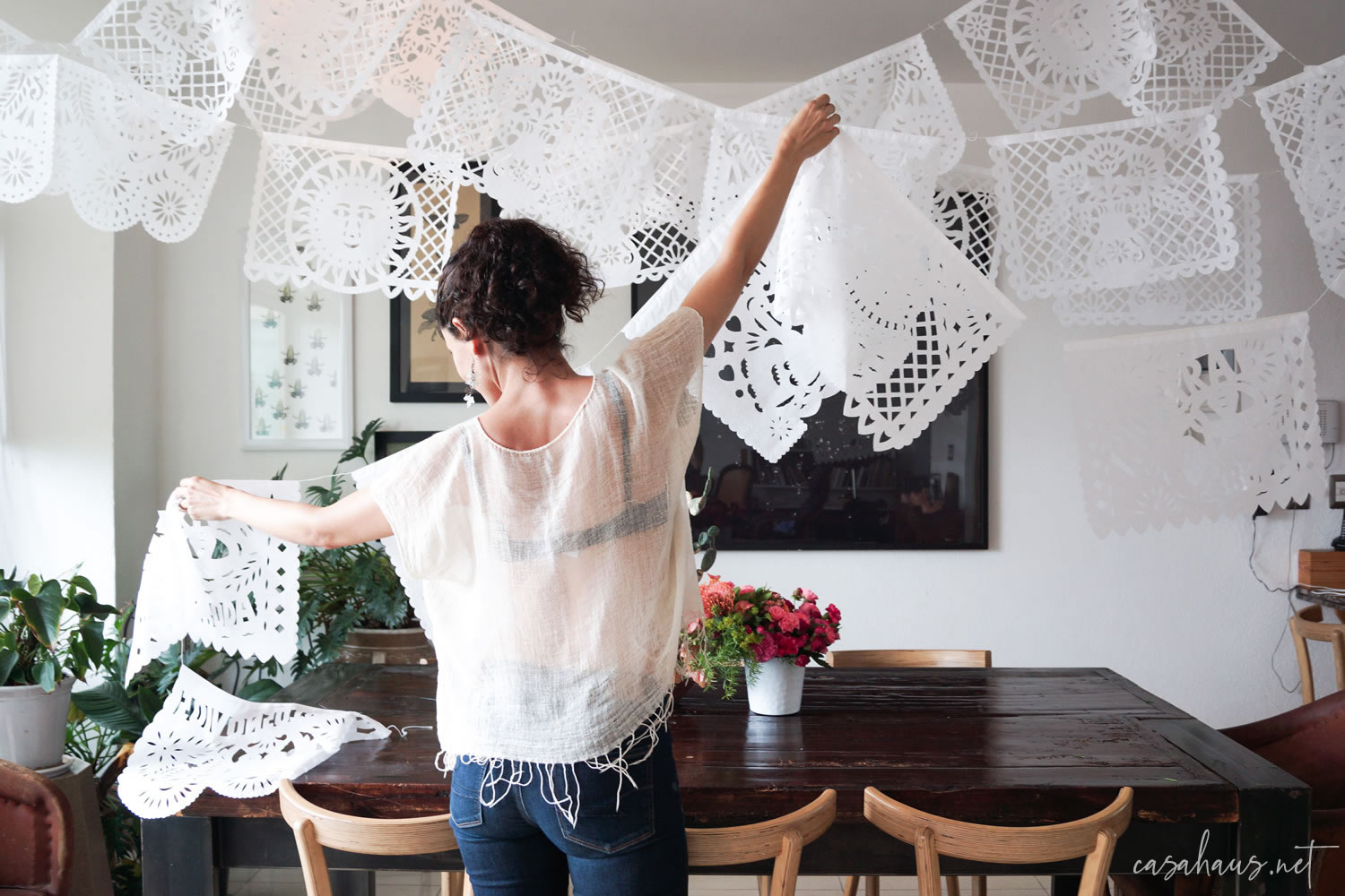 Mujer joven colgando papel picado