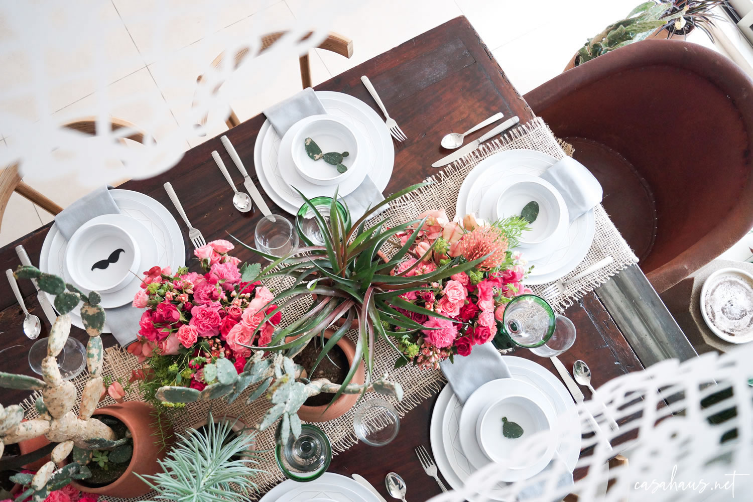 Mesa mexicana moderna con banderines de papel picado y equipal vistos desde arriba