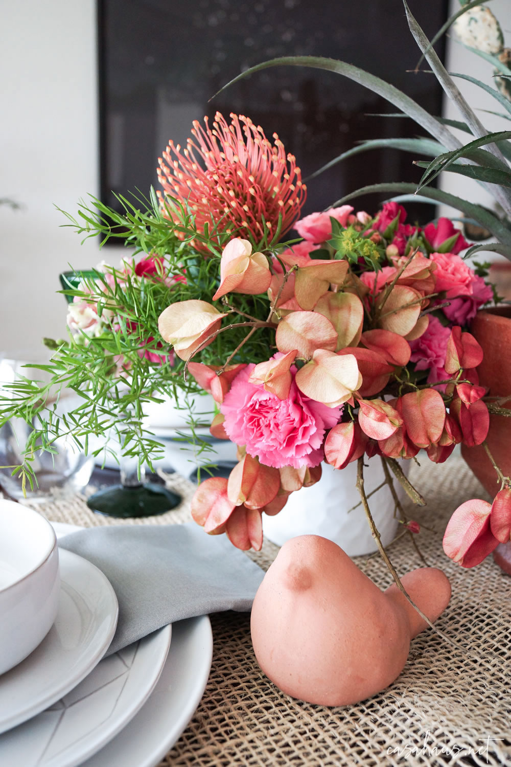 Arreglo de flores rosas sobre mesa mexicana
