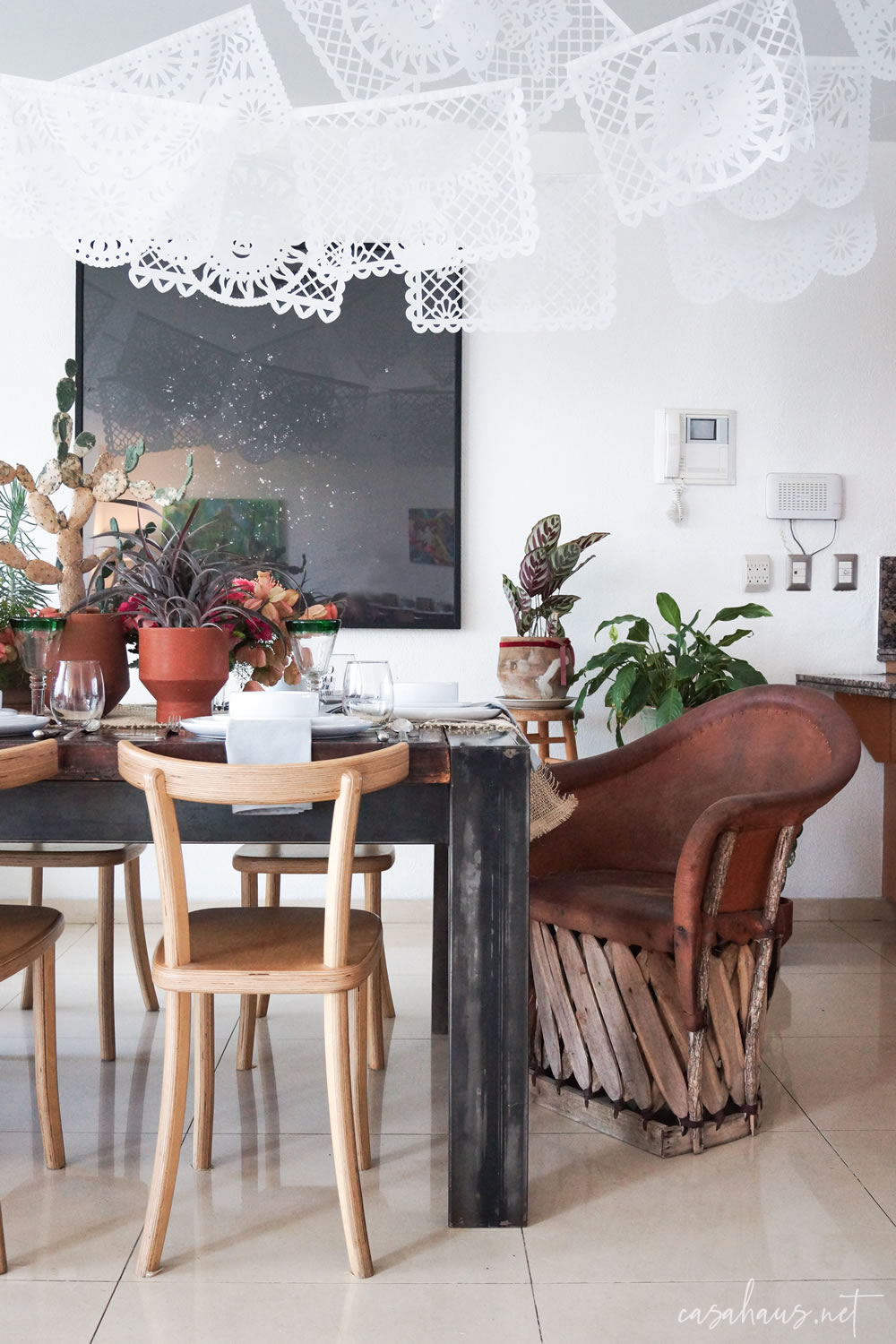 Mesa mexicana moderna con banderines de papel picado y equipal