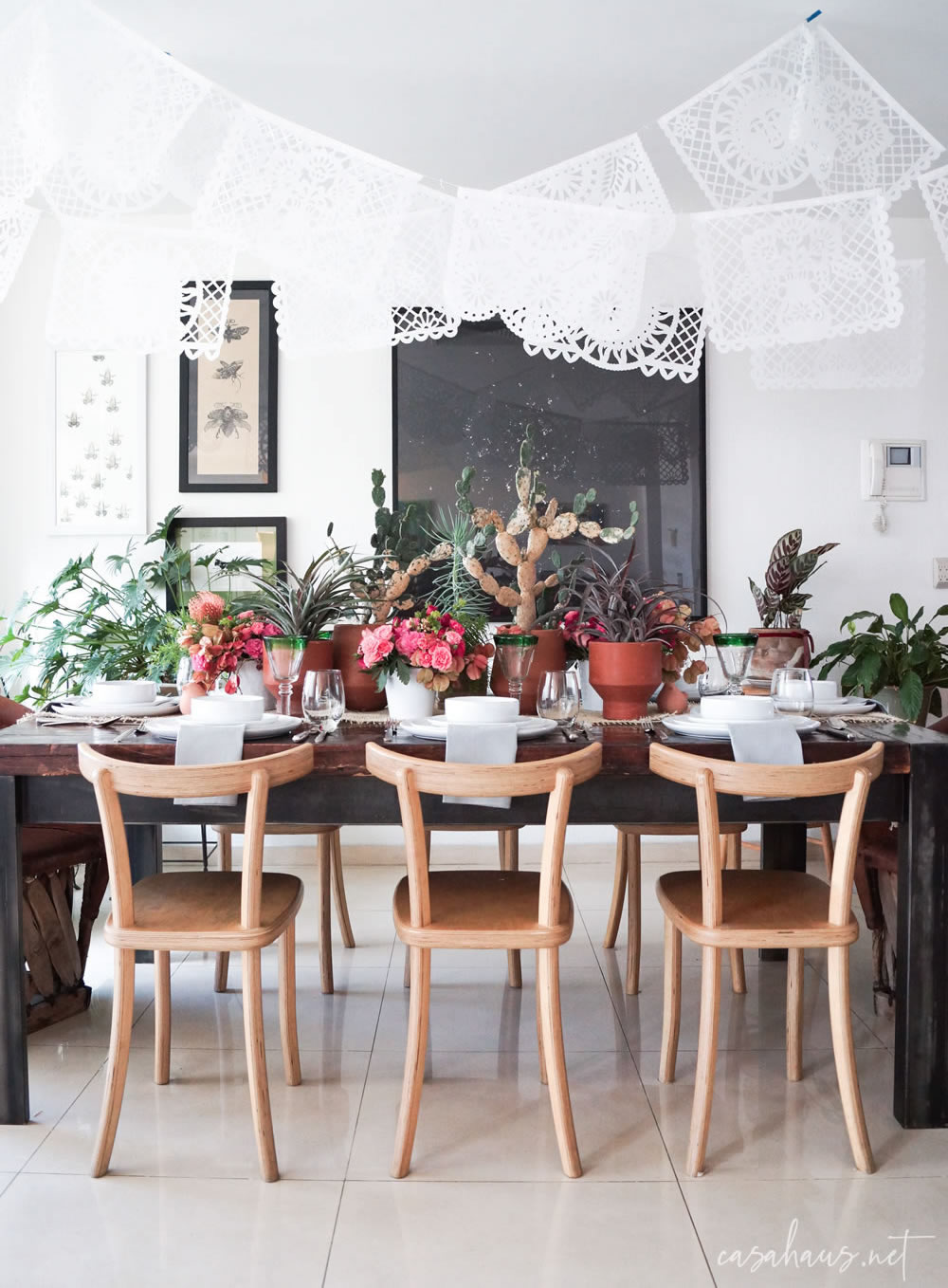 Mesa mexicana moderna con banderines de papel picado y equipal